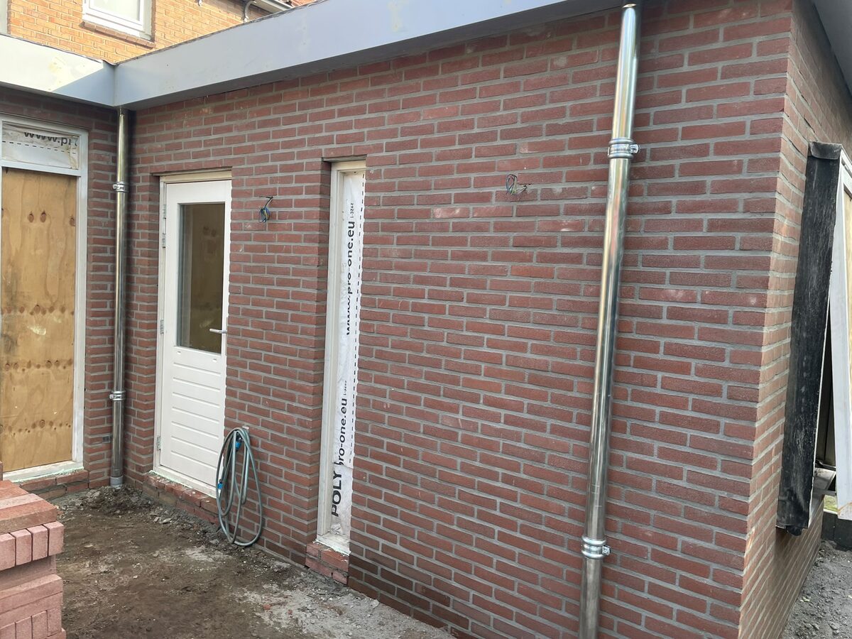 Strak gemetselde gevel met deur en kozijnen