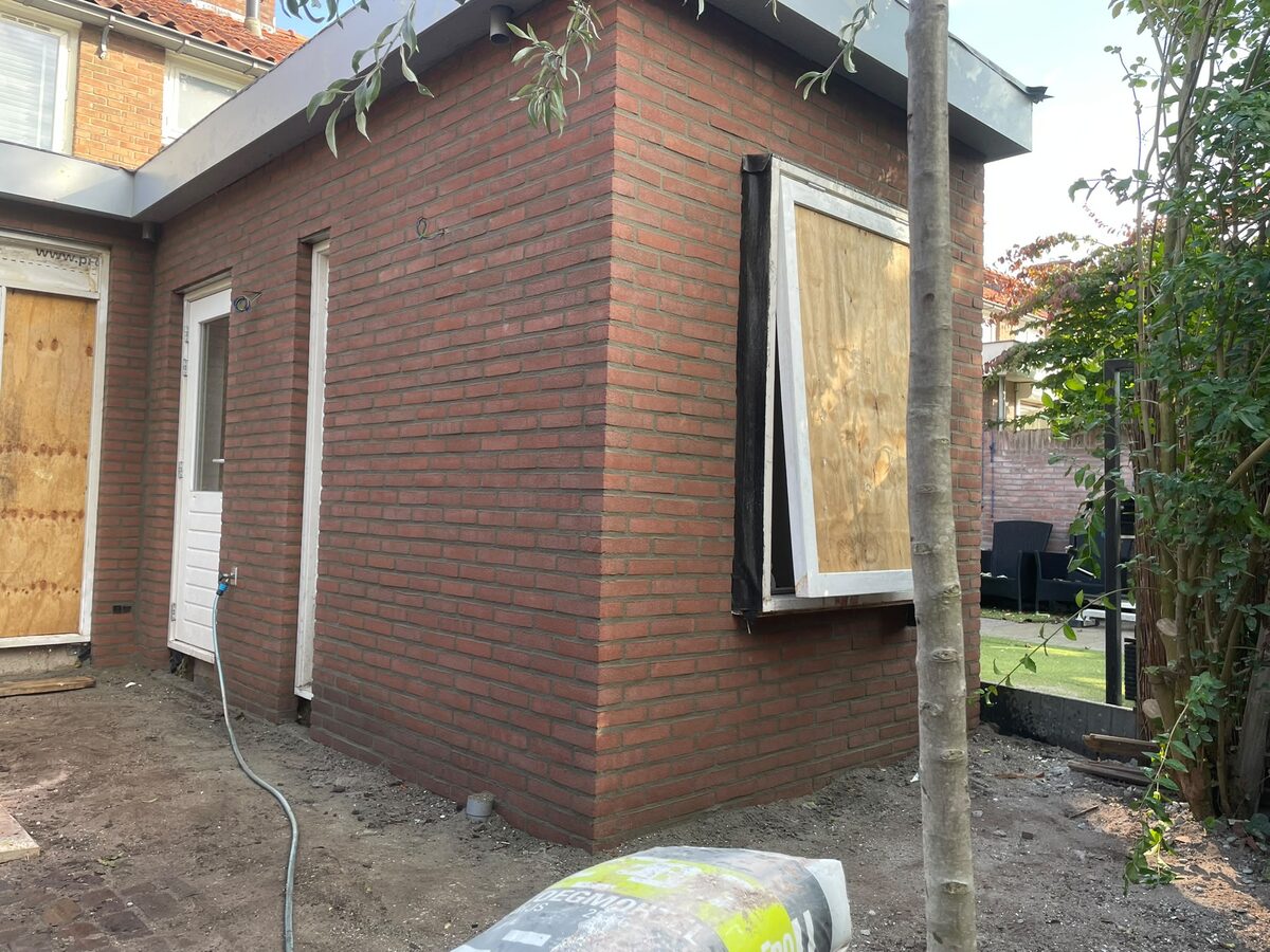 Afgewerkte hoek van een nieuwe aanbouw in baksteen